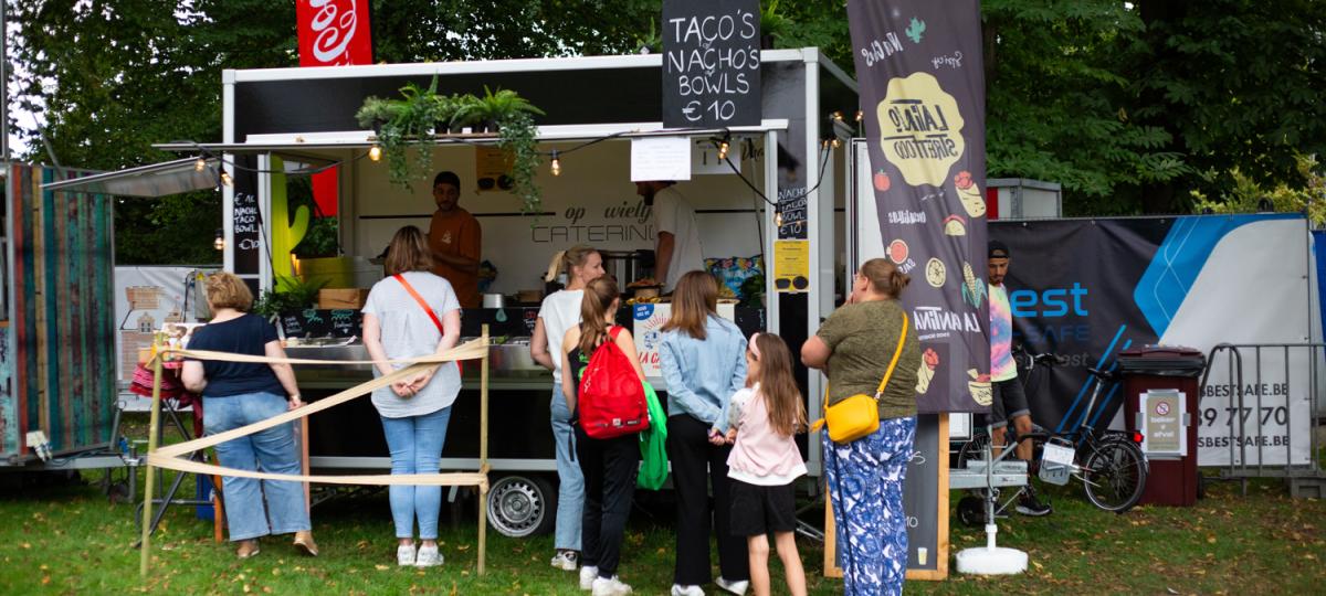Mensen schuiven aan bij een foodtruck op de Park Happening